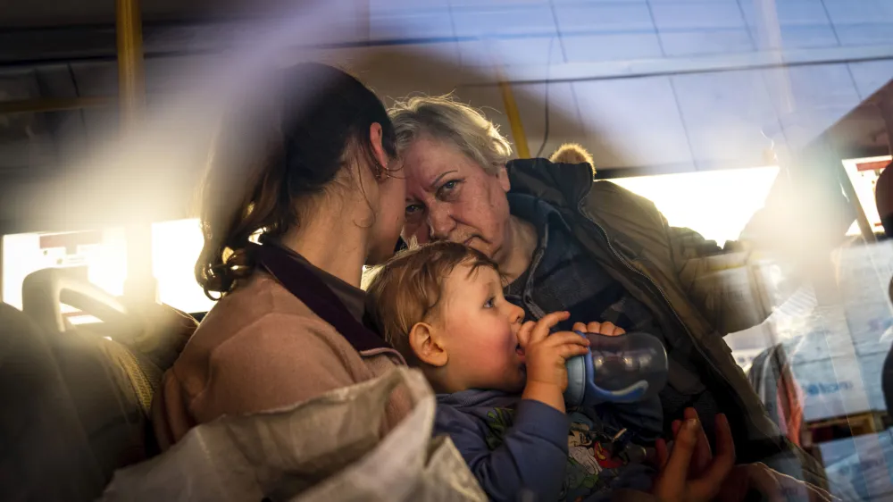 FILE - People with children wait after arriving from the Ukrainian city of Mariupol at a center for displaced people in Zaporizhzhia, Ukraine, May 3, 2022. With the evacuation of some civilians from a sprawling steel mill besieged by Russian forces, attention is turning to the fate of hundreds of Ukrainian troops still inside after weeks in the warren of underground tunnels and bunkers. (AP Photo/Evgeniy Maloletka, File)