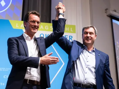 06 October 2023, Bavaria, Nuremberg: Minister President of Bavaria Markus Soeder (R) and Minister President of North Rhine-Westphalia Hendrik Wuest hold their hands during the Christian Social Union in Bavaria (CSU) state election closing rally at the Loewenbraukeller. Photo: Sven Hoppe/dpa