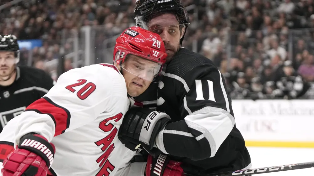 Carolina Hurricanes center Sebastian Aho, left, and Los Angeles Kings center Anze Kopitar battle for the puck during the third period of an NHL hockey game Saturday, Oct. 14, 2023, in Los Angeles. (AP Photo/Mark J. Terrill)