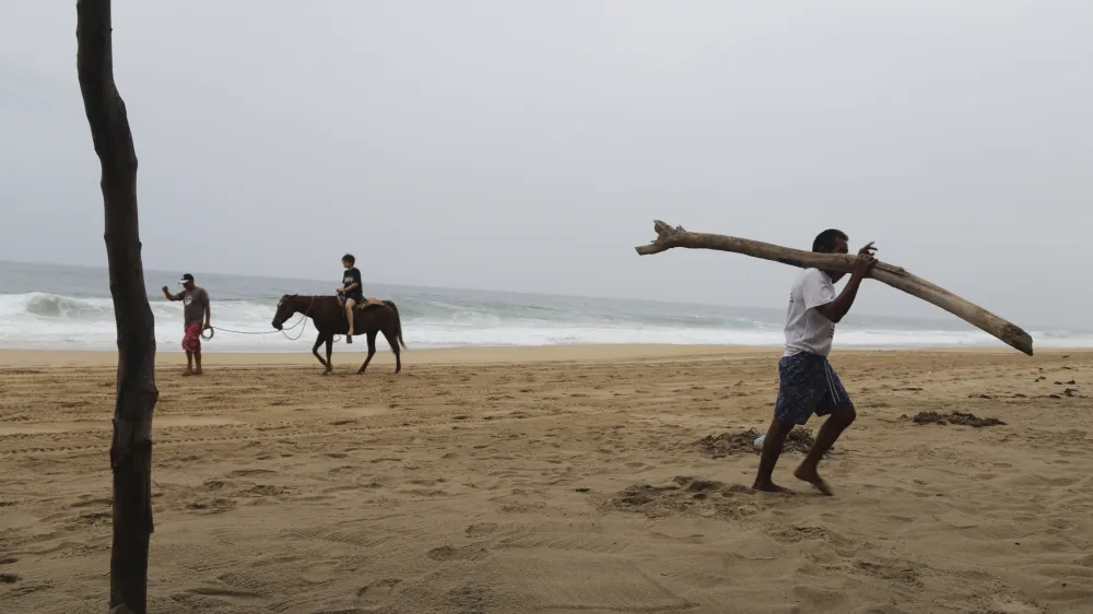 A tourist rides a horse at a beach in Acapulco, Mexico, Tuesday, Oct. 24, 2023. Hurricane Otis has strengthened from tropical storm to a major hurricane in a matter of hours as it approaches Mexico's southern Pacific coast where it was forecast to make landfall near the resort of Acapulco early Wednesday. (AP Photo/Bernardino Hernandez)