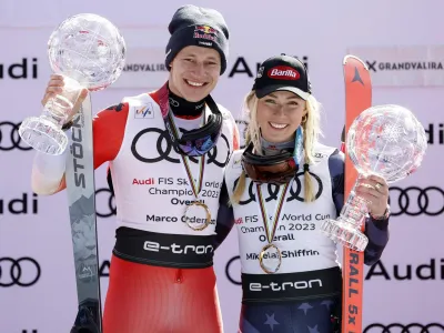 Alpine Skiing - FIS Alpine Ski World Cup - Men's Slalom - Soldeu, Andorra - March 19, 2023 Switzerland's Marco Odermatt and Mikaela Shiffrin of the U.S. celebrate on the podium with their globe trophies after winning the men's and women's overall standing REUTERS/Albert Gea