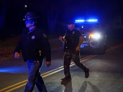 Members of law enforcement work at the scene where the body of Robert Card, the suspect in the mass shootings in Lewiston, was found in Lisbon Falls, Maine, U.S., October 27, 2023. REUTERS/Shannon Stapleton