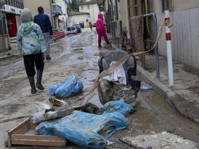 People walk in a flooded street of Campi di Bisenzio, in the central Italian Tuscany region, Friday, Nov. 3, 2023. Record-breaking rain provoked floods in a vast swath of Tuscany as storm Ciaran pushed into Italy overnight Friday, trapping people in their homes, inundating hospitals and overturning cars. At least three people were killed, and four were missing. (AP Photo/Gregorio Borgia)