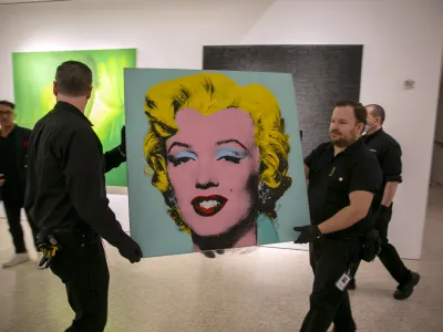 The 1964 painting Shot Sage Blue Marilyn by Andy Warhol is carried in Christie's showroom in New York City on Sunday, May 8, 2022. The auction house predicts it will sell for 0 million on Monday, becoming the most expensive 20th-century artwork to sell at auction. (AP Photo/Ted Shaffrey)