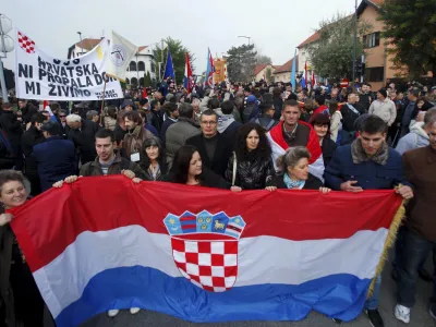 ﻿People carry a Croatian national flag during a ceremony to mark the 22th anniversary of Vukovar's fall, in downtown Vukovar November 18, 2013. The Danube town of Vukovar was entirely destroyed 22 years ago by Serb paramilitary forces backed by units of the former Yugoslav army at the beginning of Croatia's 1991-95 independence war. REUTERS/Antonio Bronic (CROATIA - Tags: CONFLICT ANNIVERSARY SOCIETY)