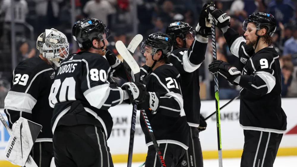 Nov 18, 2023; Los Angeles, California, USA; Los Angeles Kings center Adrian Kempe (9) high-fives with center Anze Kopitar (11) as goaltender Cam Talbot (39) and left wing Pierre-Luc Dubois (80) and defenseman Jordan Spence (21) celebrate a win after defeating the St. Louis Blues 5-1 at Crypto.com Arena. Mandatory Credit: Kiyoshi Mio-USA TODAY Sports