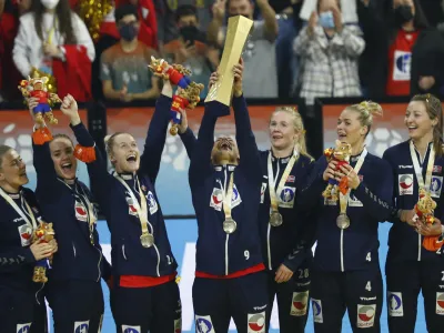 ﻿Norway's Mora Mork lifts the trophy as team players celebrate after beating France during the final of the Women's Handball World Championship in Granollers, Spain, Sunday, Dec. 19, 2021. (AP Photo/Joan Monfort)