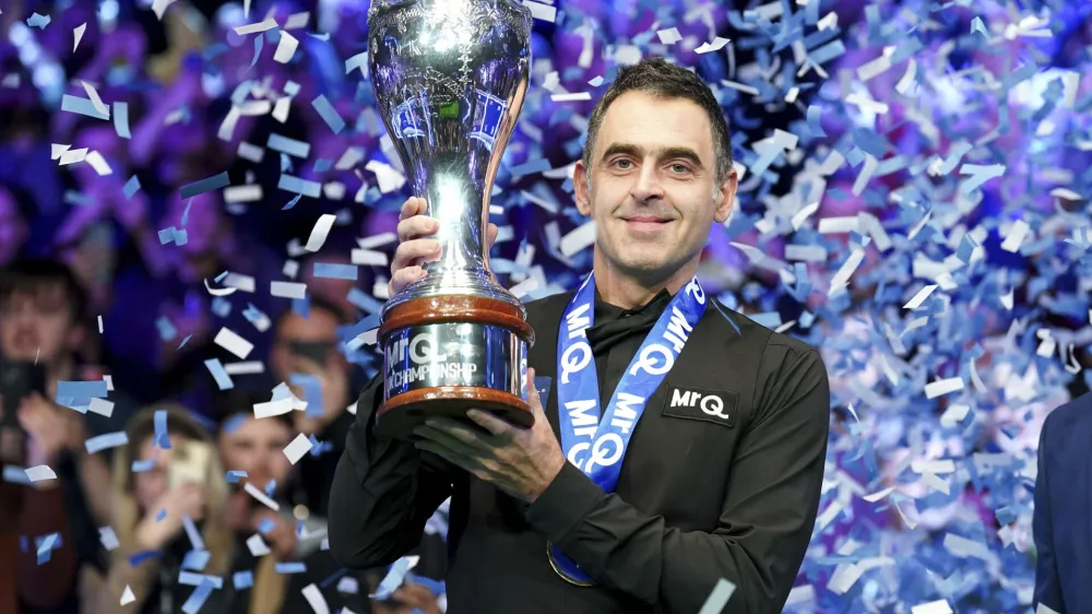 Ronnie O'Sullivan celebrates with the trophy after winning the final against Ding Junhui on day nine of the Snooker UK Championship at the York Barbican, Sunday, Dec. 3, 2023, in York, England. (Mike Egerton/PA via AP)