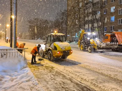 Municipal workers clear snow from the sidewalks and a road after heavy snowfall in Moscow, Russia, Monday, Dec. 4, 2023. A record snowfall has hit Russia's capital bringing an additional 10 cm (3,9 inches) to already high levels of snow and causing disruption at the capital's airports and on roads. (Denis Voronin)/Moscow News Agency via AP)