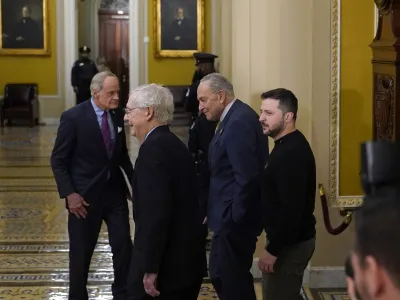 Ukrainian President Volodymyr Zelenskyy, right, walks with Senate Majority Leader Chuck Schumer of N.Y., second from right, and Senate Minority Leader Mitch McConnell of Ky., second from left, following a meeting with senators on Capitol Hill in Washington, Tuesday, Dec. 12, 2023. Sen. Tom Carper, D-Del., is at left. (AP Photo/Susan Walsh)