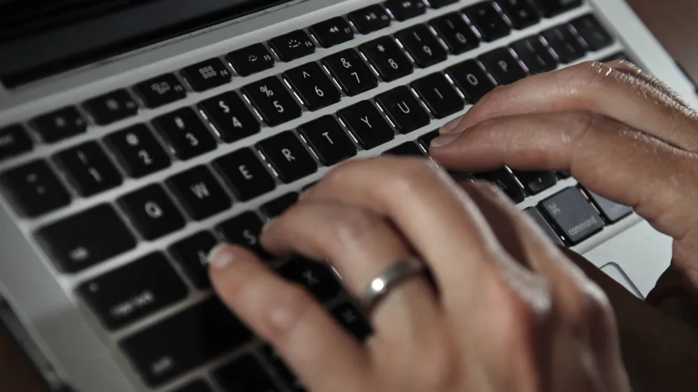 FILE- A person types on a laptop keyboard in North Andover, Mass, June 19, 2017. The U.S. government will restrict its use of commercial spyware tools that have been used to surveil human rights activists, journalists and dissidents around the world, under an executive order issued Monday, Oct. 27, 2023, by President Joe Biden. (AP Photo/Elise Amendola, File)