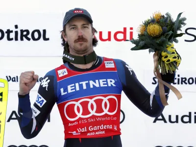 United States' Bryce Bennett celebrates on the podium after winning an alpine ski, men's World Cup downhill race, in Val Gardena, Italy, Thursday, Dec. 14, 2023. (AP Photo/Alessandro Trovati)