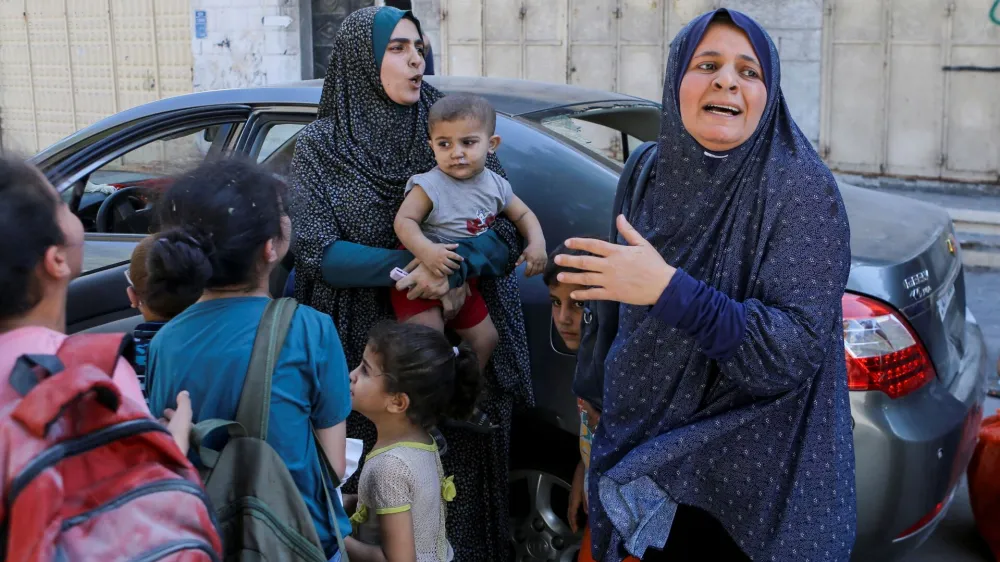 Palestinian women and children react following Israeli strikes in Gaza City October 15, 2023. REUTERS/Mutasem Murtaja