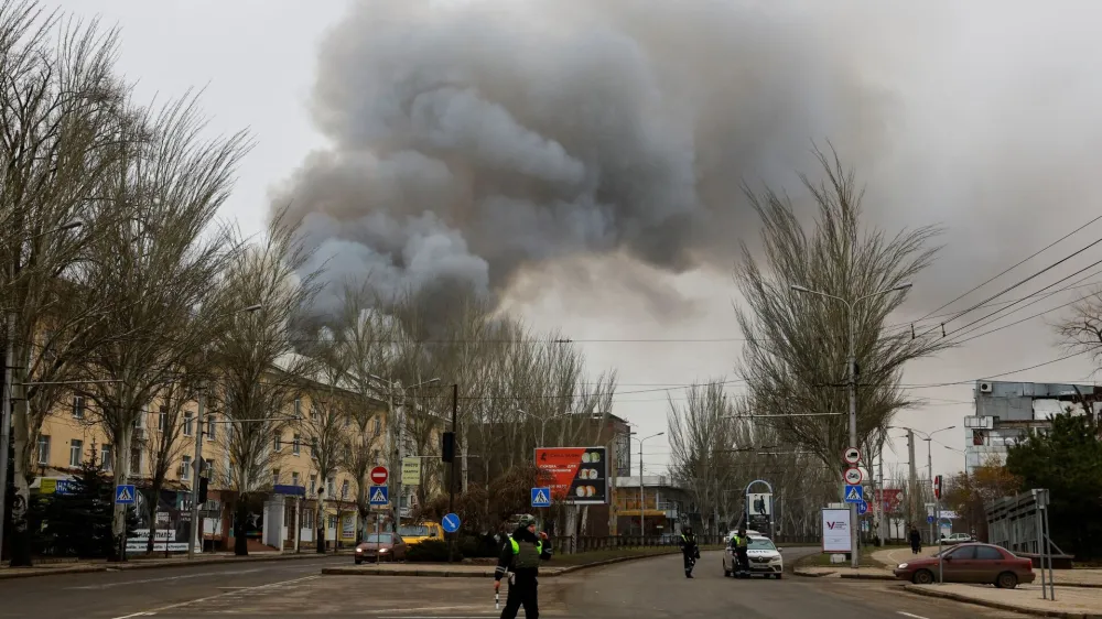 Traffic police officers block a road as smoke rises above buildings following recent shelling in the course of Russia-Ukraine conflict in Donetsk, Russian-controlled Ukraine, December 21, 2023. REUTERS/Alexander Ermochenko