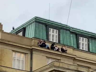 People watch from a roof following a shooting at one of the buildings of Charles University, in Prague, Czech Republic, December 21, 2023, as seen in this screen grab taken from a social media video. Ivo Havranek/via REUTERS THIS IMAGE HAS BEEN SUPPLIED BY A THIRD PARTY. MANDATORY CREDIT. NO RESALES. NO ARCHIVES.