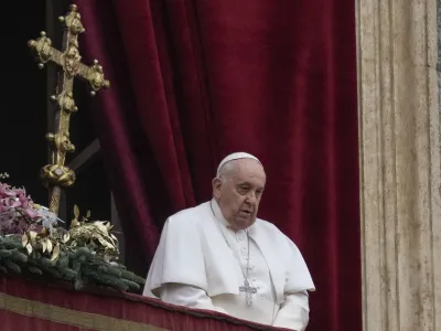 Pope Francis stands before delivering the Urbi et Orbi (Latin for 'to the city and to the world') Christmas' day blessing from the main balcony of St. Peter's Basilica at the Vatican, Monday Dec. 25, 2023. (AP Photo/Gregorio Borgia)