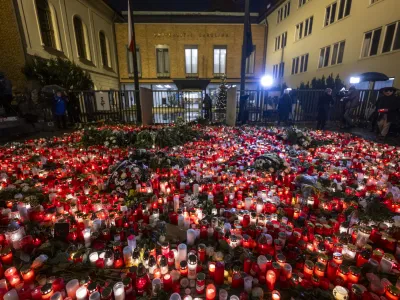 22 December 2023, Czech Republic, Prague: People light candles and place flowers at a makeshift memorial in front of the building of the Faculty of Philosophy of Charles University for the victims of the deadly shooting. On Thursday afternoon, a shooter opened fire at a university in central Prague, killing at least 14 people and injuring 25, 10 of whom were critically. Photo: Říhová Michaela/CTK/dpa