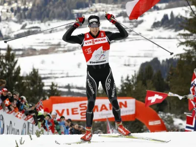 Dario Cologna of Switzerland celebrates after crossing the finish line to win the men's FIS Tour de Ski 9km free final climb pursuit start from the Lago di Tesero track to Cermis in Val di Fiemme January 8, 2012. Cologna won the race and the Tour de Ski ahead of Marcus Hellner of Sweden and Petter Northug of Norway. REUTERS/Alessandro Garofalo (ITALY - Tags: SPORT SKIING PROFILE)