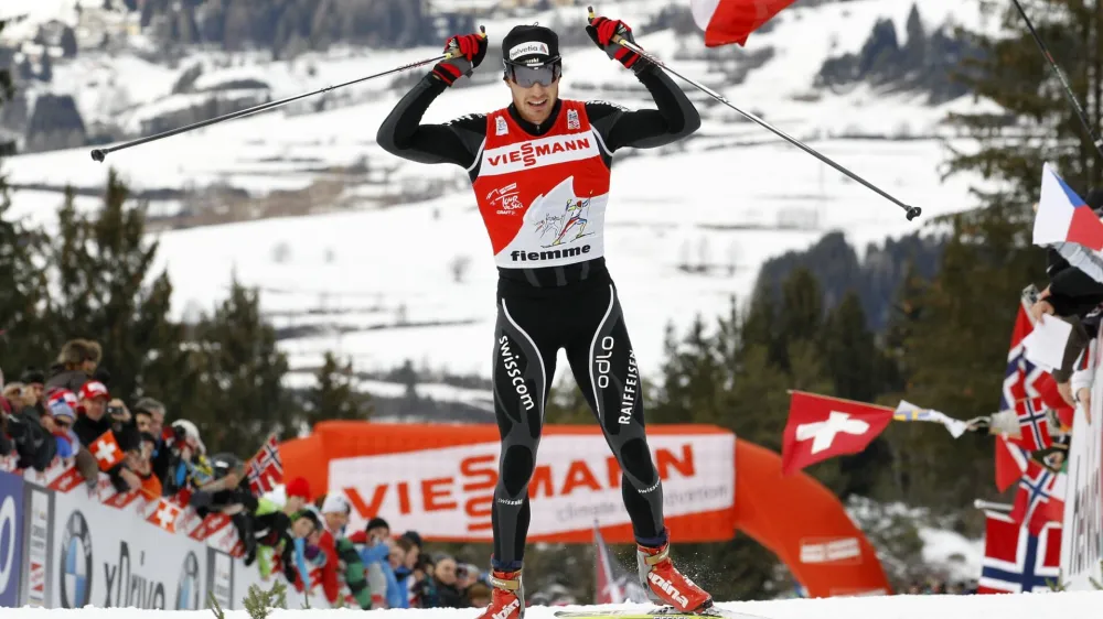 Dario Cologna of Switzerland celebrates after crossing the finish line to win the men's FIS Tour de Ski 9km free final climb pursuit start from the Lago di Tesero track to Cermis in Val di Fiemme January 8, 2012. Cologna won the race and the Tour de Ski ahead of Marcus Hellner of Sweden and Petter Northug of Norway. REUTERS/Alessandro Garofalo (ITALY - Tags: SPORT SKIING PROFILE)