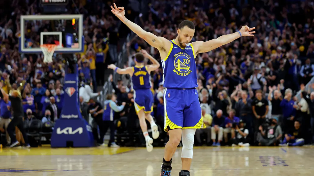 Golden State Warriors' Stephen Curry (30) celebrates a 3-pointer by Klay Thompson's against the Memphis Grizzles during the second half in Game 6 of the Western Conference semifinals of the NBA basketball playoffs in San Francisco on Friday, May 13, 2022. The Warriors defeated the Grizzlies 110-96 to advance to the conference finals. (Carlos Avila Gonzalez/San Francisco Chronicle via AP)