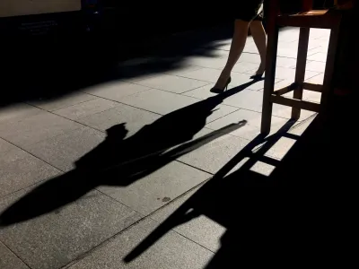 FILE PHOTO: A woman casts a shadow as she walks along a footpath past a coffee shop on a sunny, winter day in central Sydney, Australia July 25, 2017. REUTERS/David Gray/File Photo