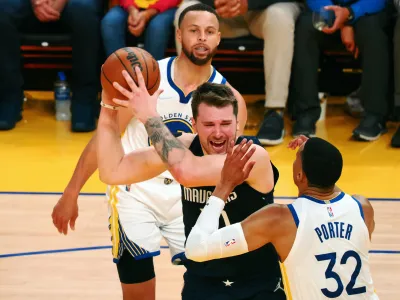 May 20, 2022; San Francisco, California, USA; Dallas Mavericks guard Luka Doncic (77) looks to pass the ball between Golden State Warriors guard Stephen Curry (30) and forward Otto Porter Jr. (32) during the third quarter of game two of the 2022 western conference finals at Chase Center. Mandatory Credit: Kelley L Cox-USA TODAY Sports