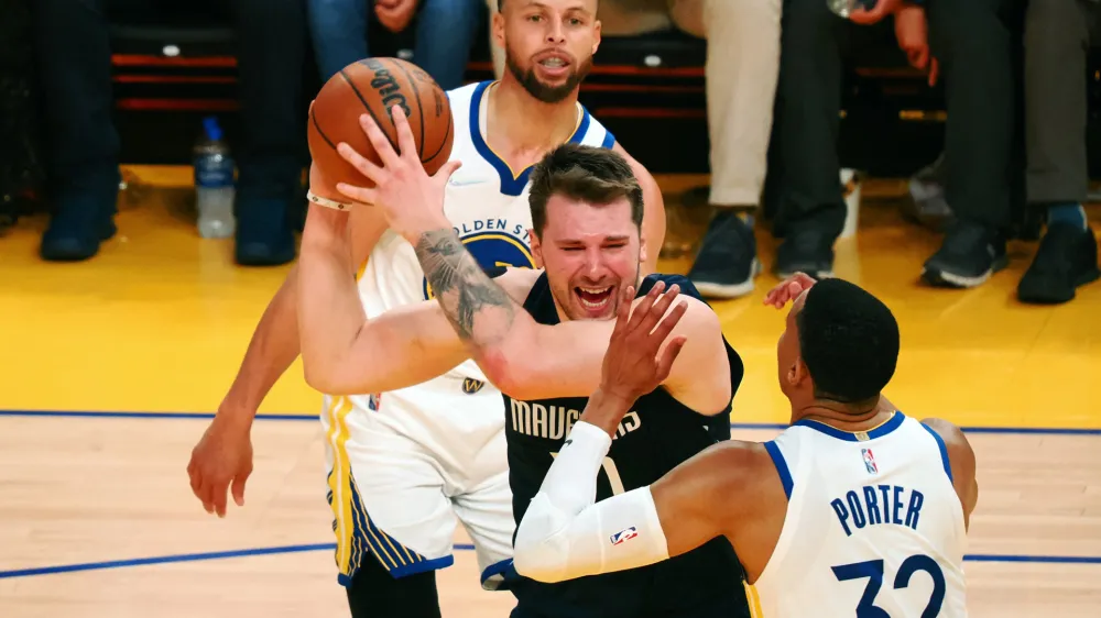 May 20, 2022; San Francisco, California, USA; Dallas Mavericks guard Luka Doncic (77) looks to pass the ball between Golden State Warriors guard Stephen Curry (30) and forward Otto Porter Jr. (32) during the third quarter of game two of the 2022 western conference finals at Chase Center. Mandatory Credit: Kelley L Cox-USA TODAY Sports