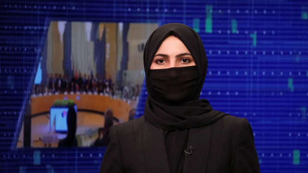 A female presenter for Tolo News, Sonia Niazi, while covering her face, works in a newsroom at Tolo TV station in Kabul, Afghanistan, May 22, 2022. REUTERS/Ali Khara