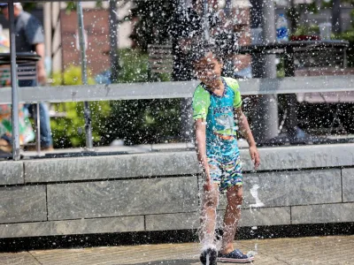 Lucca Essomba, 6 years old of Boston, MA plays in the fountains in the North End Park as the U.S. East Coast is hit by heat wave, in Boston, Massachusetts, U.S. May 22, 2022. REUTERS/Katherine Taylor