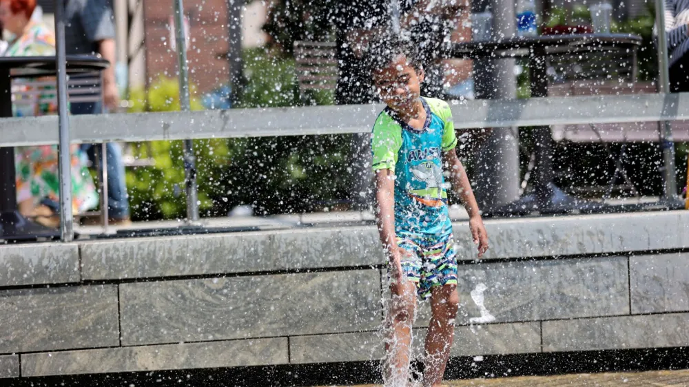 Lucca Essomba, 6 years old of Boston, MA plays in the fountains in the North End Park as the U.S. East Coast is hit by heat wave, in Boston, Massachusetts, U.S. May 22, 2022. REUTERS/Katherine Taylor