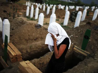 A Bosnian Muslim woman cries near a new open grave with the coffin of her relative, which was prepared for a mass burial at the Memorial Center in Potocari, near Srebrenica July 10, 2012. The bodies of 520 recently identified victims of the Srebrenica massacre will be buried on July 11, the anniversary of the massacre when Bosnian Serb forces commanded by Ratko Mladic slaughtered 8,000 Muslim men and boys and buried them in mass graves, in Europe's worst massacre since World War Two. REUTERS/Dado Ruvic (BOSNIA - Tags: CONFLICT POLITICS ANNIVERSARY TPX IMAGES OF THE DAY)