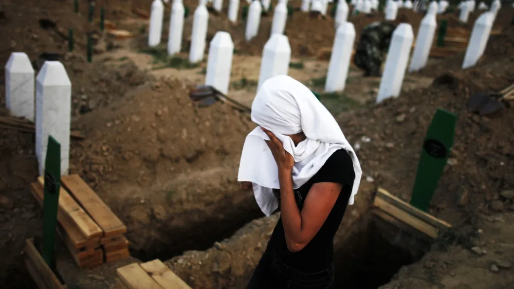 A Bosnian Muslim woman cries near a new open grave with the coffin of her relative, which was prepared for a mass burial at the Memorial Center in Potocari, near Srebrenica July 10, 2012. The bodies of 520 recently identified victims of the Srebrenica massacre will be buried on July 11, the anniversary of the massacre when Bosnian Serb forces commanded by Ratko Mladic slaughtered 8,000 Muslim men and boys and buried them in mass graves, in Europe's worst massacre since World War Two. REUTERS/Dado Ruvic (BOSNIA - Tags: CONFLICT POLITICS ANNIVERSARY TPX IMAGES OF THE DAY)