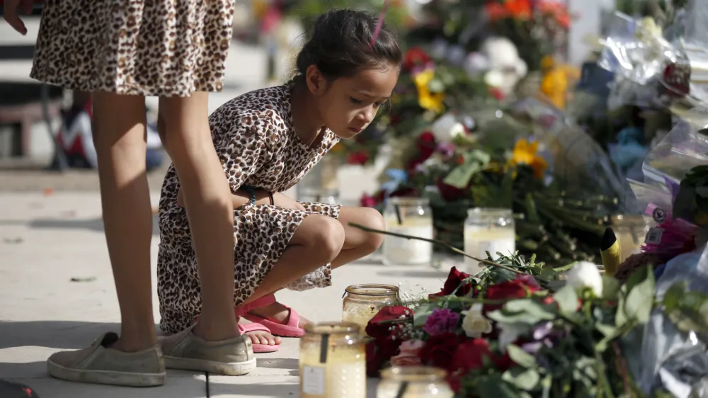 A child looks at a memorial site for the victims killed in this week's shooting at Robb Elementary School in Uvalde, Texas, Friday, May 27, 2022. (AP Photo/Dario Lopez-Mills)