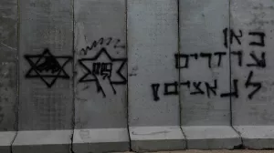 A blast wall sits marked with graffiti at the Kerem Shalom border crossing, as military operations continue in the southern Gaza city of Rafah, at an area outside Kerem Shalom, Israel, May 17, 2024. REUTERS/Shannon Stapleton