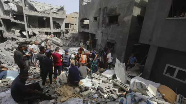 Palestinians look at the destruction after an Israeli strike on a residential building in Nuseirat Refugee Camp, Gaza Strip, Sunday, May 19, 2024. (AP Photo/Ismael Abu Dayyah)