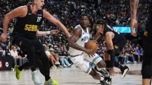 Minnesota Timberwolves guard Anthony Edwards, center, drives to the basket between Denver Nuggets center Nikola Jokic, left, and forward Aaron Gordon in the second half of Game 7 of an NBA second-round playoff series Sunday, May 19, 2024, in Denver. (AP Photo/David Zalubowski)