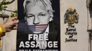 A protester holds a poster of WikiLeaks founder Julian Assange outside the High Court in London, Monday, May 20, 2024. A British court has ruled that WikiLeaks founder Julian Assange can appeal against an order that he be extradited to the U.S. on espionage charges. (AP Photo/Kin Cheung)