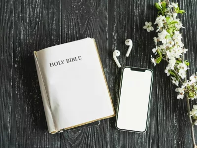 Study Bible worship online concept. Church online Sunday new normal concept. Bible, cell phone and earbuds on a wood background. Home church