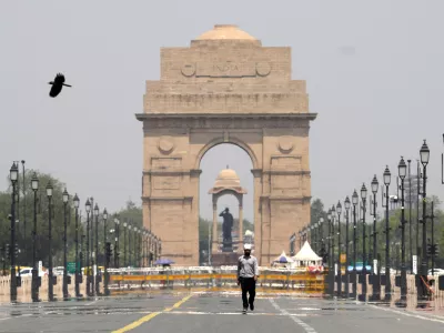 A man walks past the India Gate monument on a hot summer day in New Delhi, India, Monday, May 27, 2024. (AP Photo/Manish Swarup)