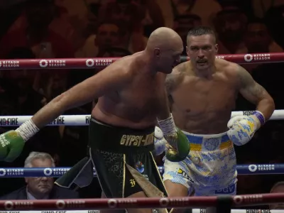 Ukraine's Oleksandr Usyk, right, pursues Britain's Tyson Fury during their undisputed heavyweight world championship boxing fight at the Kingdom Arena in Riyadh, Saudi Arabia, Sunday, May 19, 2024. (AP Photo/Francisco Seco)