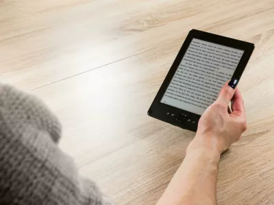 HTC209 Woman holding ebook reader in front of the table