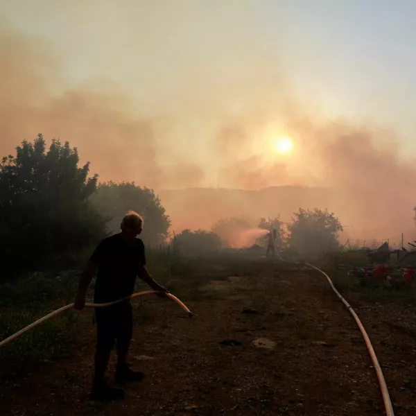 A man holds a hose, as another person uses a hose to extinguish flames, amid ongoing cross-border hostilities between Hezbollah and Israeli forces, in Dishon, near Kiryat Shmona, northern Israel, June 4, 2024. REUTERS/Ammar Awad   TPX IMAGES OF THE DAY