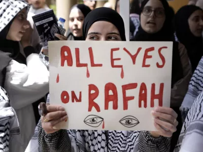 FILE - A student holds a placard as she chants slogans during a protest inside the American University of Beirut to show support for Palestinians in the Gaza Strip, in Beirut, Lebanon, Tuesday, May 7, 2024. A single image, not even an authentic photograph, is the focus of a singular campaign on Instagram that has caught the attention of the algorithm and captured the imaginations of users across national borders — a show of support for the Palestinian movement as the war between Israel and Hamas enters its eighth month. (AP Photo/Bilal Hussein, File)