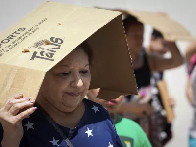 FILE - Margaret Cantu waits in the heat for food and water from volunteers Saturday, May 18, 2024, at Sam Houston Math, Science and Technology Center in Houston. (Jon Shapley/Houston Chronicle via AP)/Houston Chronicle via AP, File)