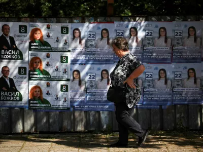 A woman walks past election posters, ahead of the upcoming snap parliamentary and European elections on June 9, in the town of Dupnitsa, Bulgaria, June 5, 2024. REUTERS/Spasiyana Sergieva