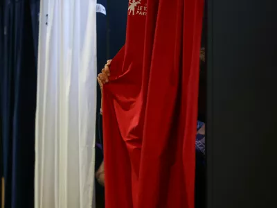 A person pulls the curtain inside a voting booth during the European Parliament election, in Le Touquet-Paris-Plage, France, June 9, 2024. REUTERS/Hannah McKay