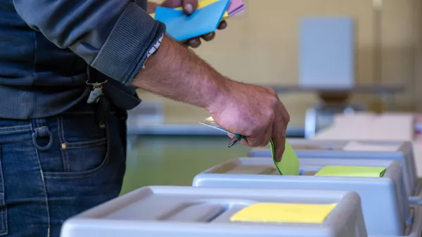 09 June 2024, Rhineland-Palatinate, Schweich: A man drops his ballot paper into the ballot box to cast his vote. In Rhineland-Palatinate, local elections and the European elections take place on the same day. Photo: Harald Tittel/dpa