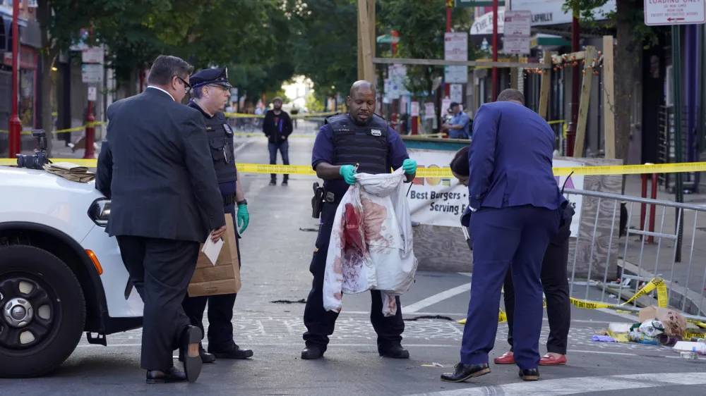 Philadelphia Police investigators work the scene of a fatal overnight shooting on South Street in Philadelphia, Sunday, June 5, 2022. (AP Photo/Michael Perez)