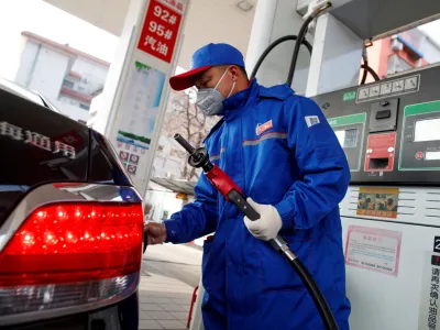 FILE PHOTO: A pump attendant refuels a car at a Sinopec gas station in Beijing, China, February 28, 2020. REUTERS/Thomas Peter/File Photo