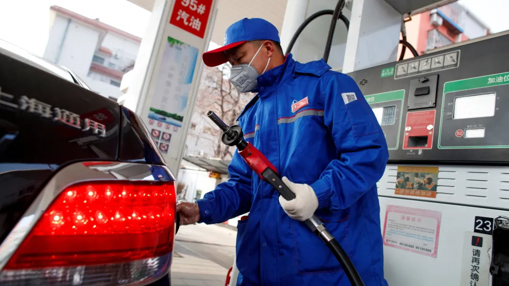 FILE PHOTO: A pump attendant refuels a car at a Sinopec gas station in Beijing, China, February 28, 2020. REUTERS/Thomas Peter/File Photo